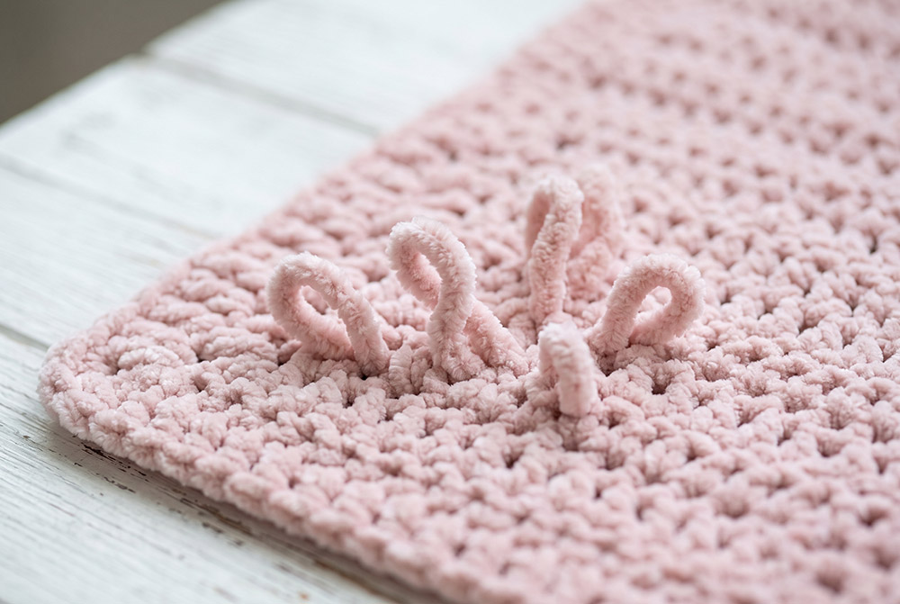 Boucles de fil chenille qui ressortent d'une couverture crochetée trop lâche (worming)